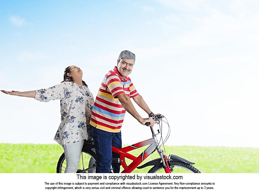 Happy Indian Old Couple Together Riding Bicycle Fun Cheerful At Park