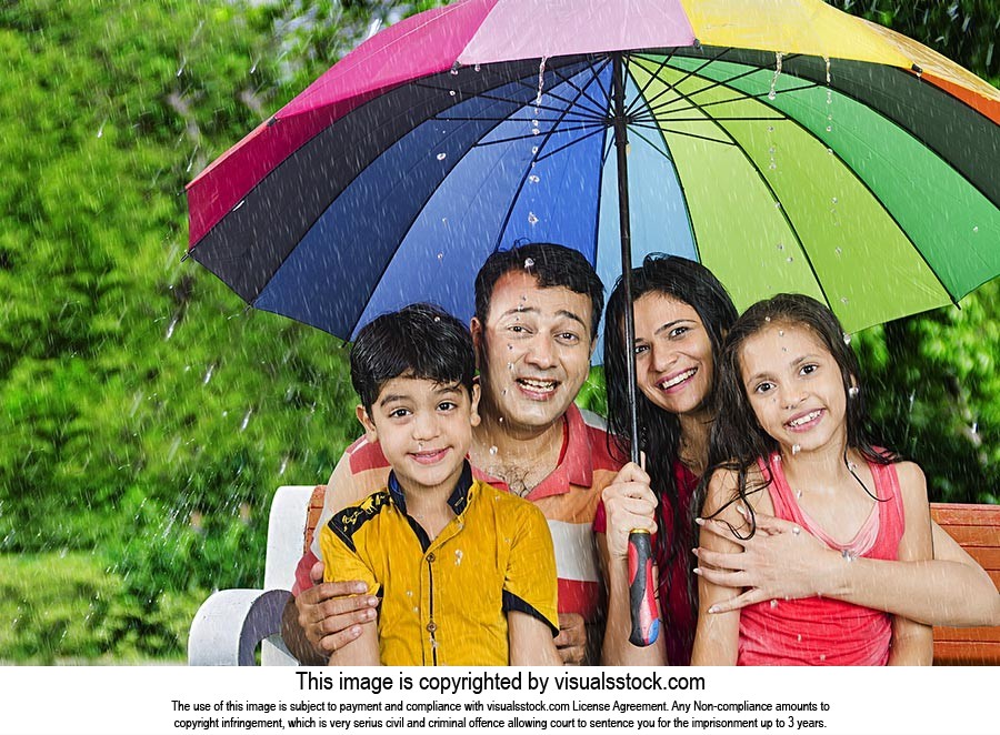 Family Sheltering Rain Under Umbrella
