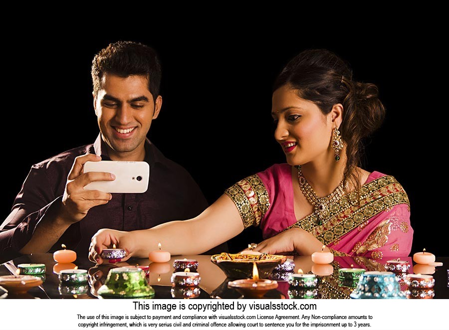 Couple Lighting Diyas Clicking Picture