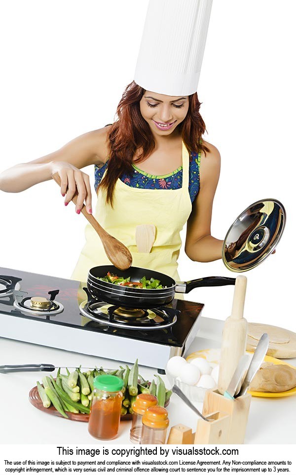 Portrait of Happy Indian teenage girl in kitchen holding cooking