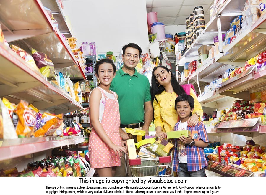 Indian Family With Food In Shopping Cart At Grocery Store