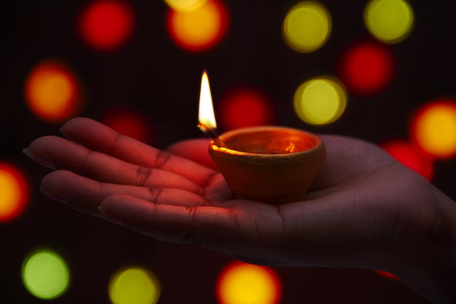 Close-up Indian woman open hands holding diya light on-diwali festival