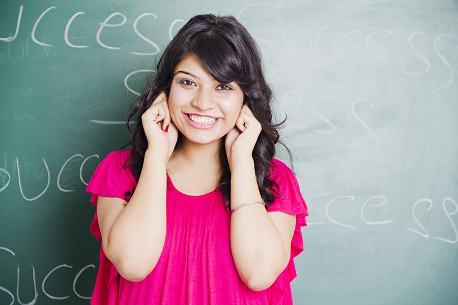 college-girl-student-saying-sorry-holding-ears-standing-in-classroom