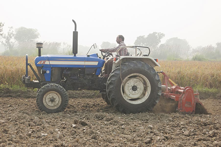 Indian Rural Farmer Man Driving Tractor farm Working