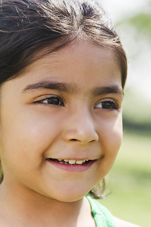 Beautiful kid girl smiling Face in-the park looking-Away