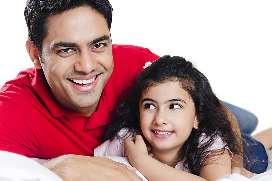 Indian Father And Little Daughter Lying Bed Together At Home