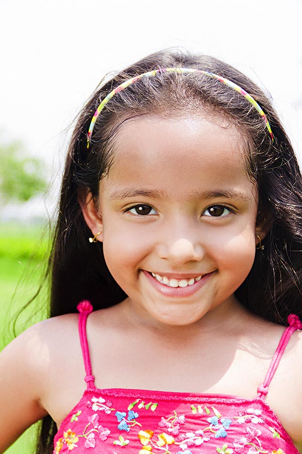 Portrait-of Cute Little Girl Looking-at-camera And Smiling in park