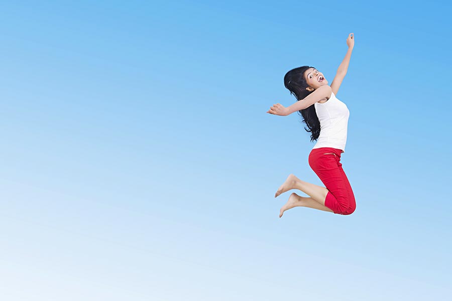 Happy Young-Woman Jumping-Up Mid-Air Having Fun Cheerful