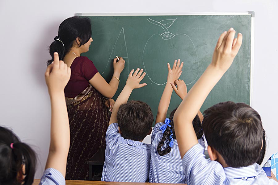 School Teacher Writing Chalkboard With Student raising-hand to-answer ...