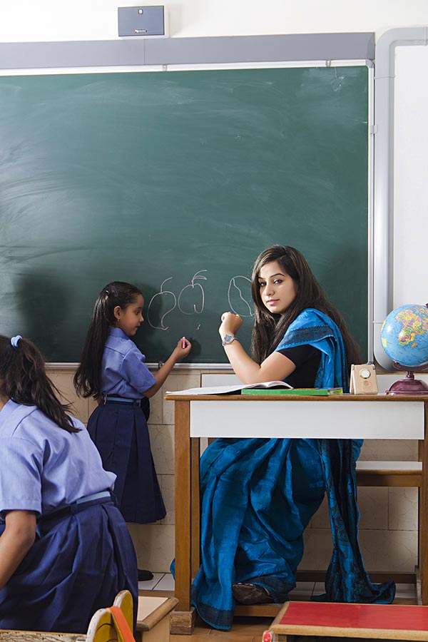 Primary-School Child-Girl student writing On-blackboard with teacher ...