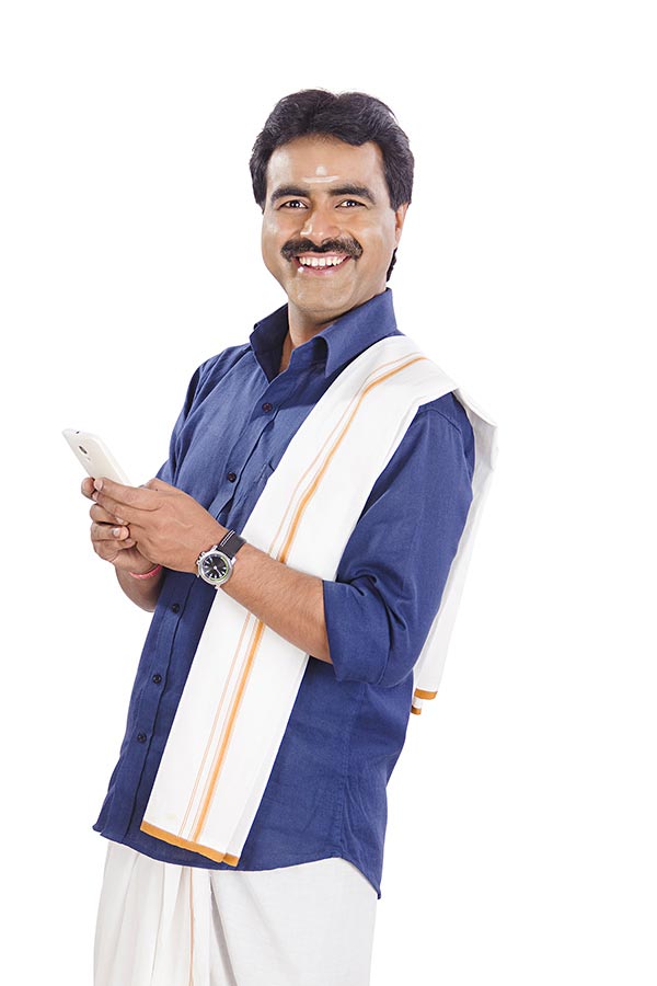 south-indian-male-in-traditional-dress-sending-text-messaging-on