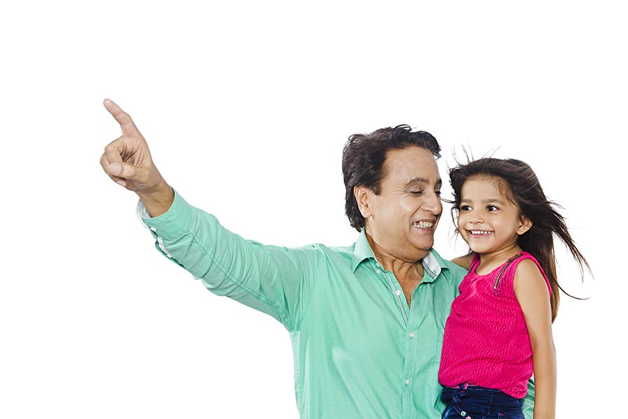 Happy Indian Grandfather carrying his granddaughter Pointing Finger At ...