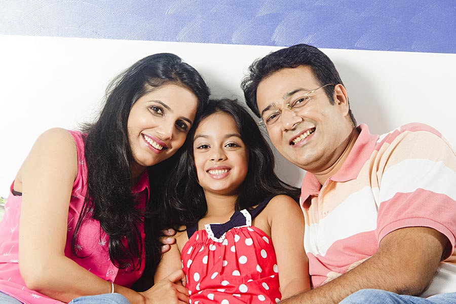 Indian Family parents And Daughter Sitting Bed Together Relaxing Bedroom