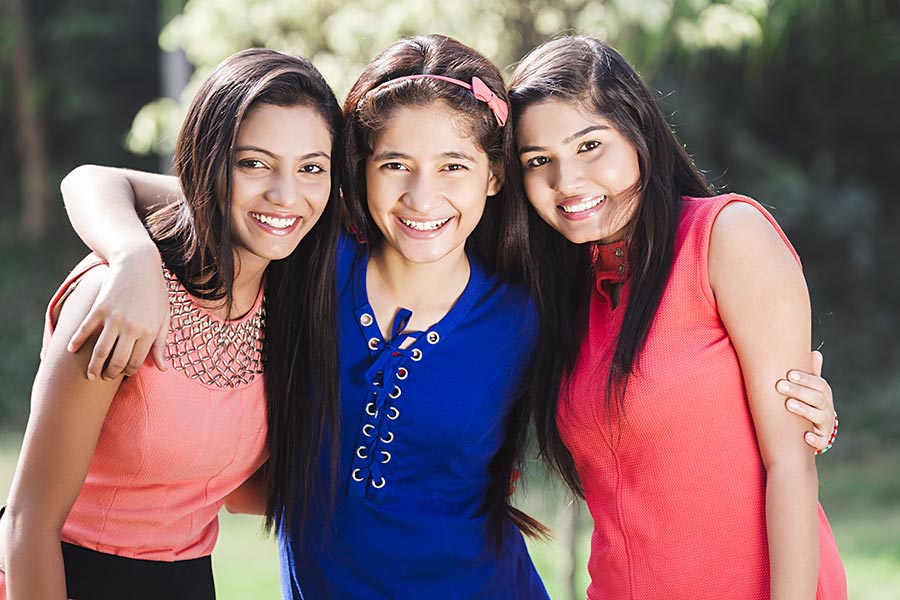 Indian Teenager Girls Friends Arm Around Standing Together In Park