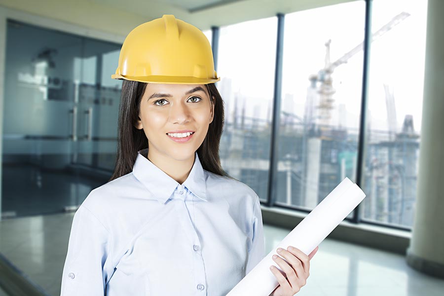 Indian woman civil engineer holding blueprints Building Construction Site