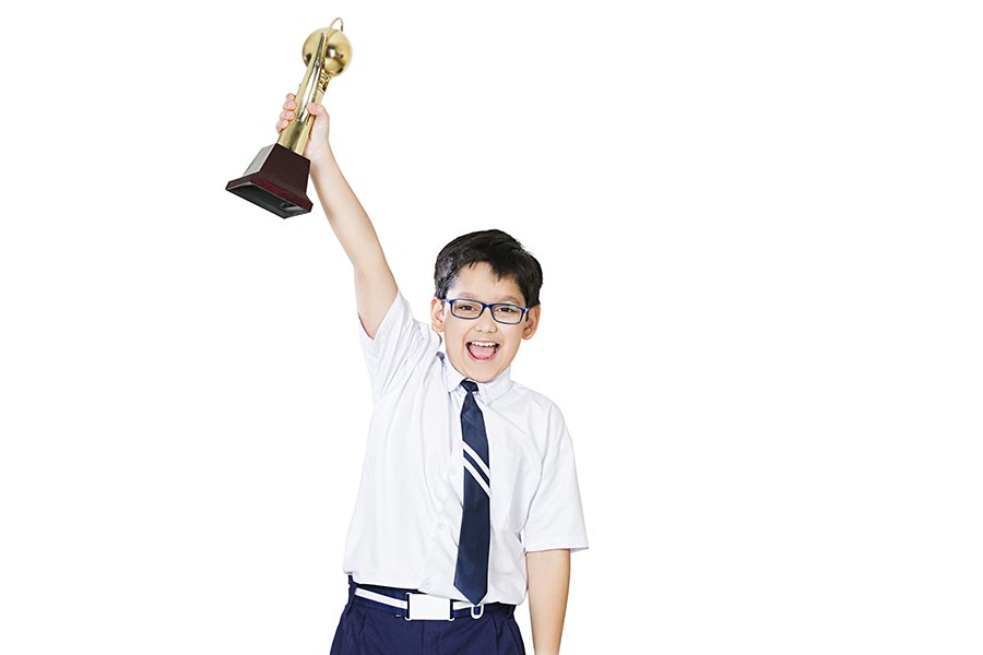 Indian Elementary School Boy Student Winning Trophy Cheerful