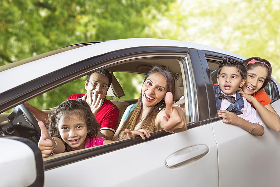 Happy Family Sitting In Car Showing Thumbs-uptraveling While On Picnic