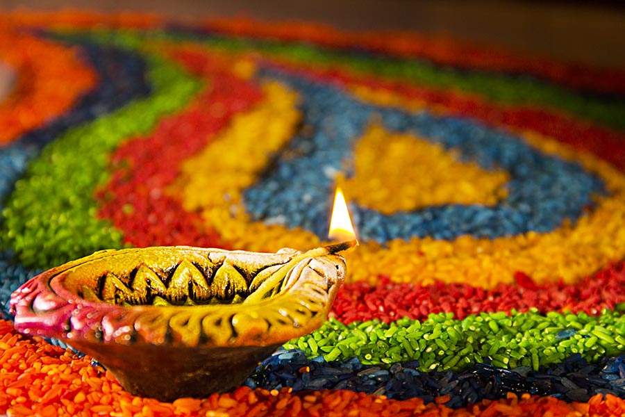 Traditional-Diya Oil-lamp lit-on Colorful Rangoli made up-of Rice On ...