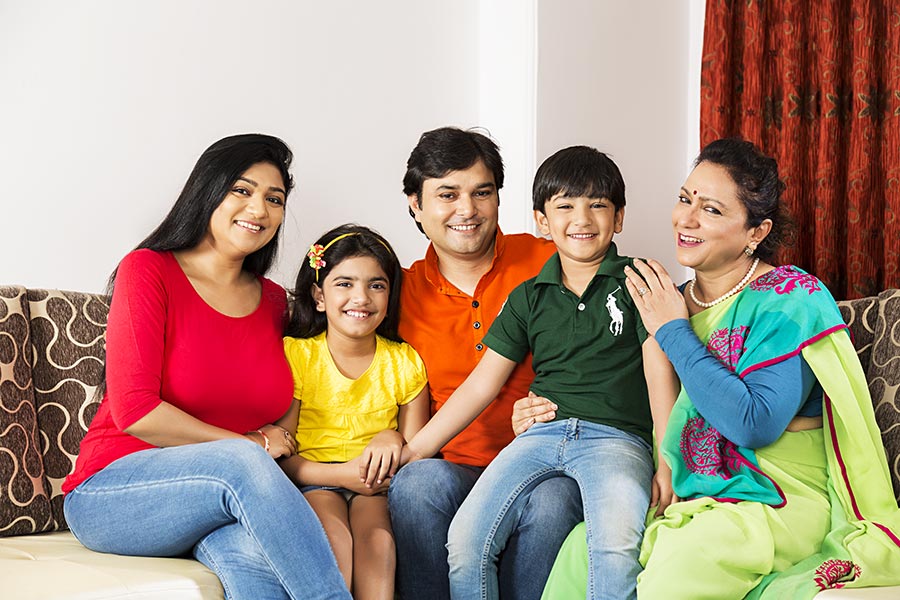 Happy Indian Family With Children Sitting Sofa Together At Home