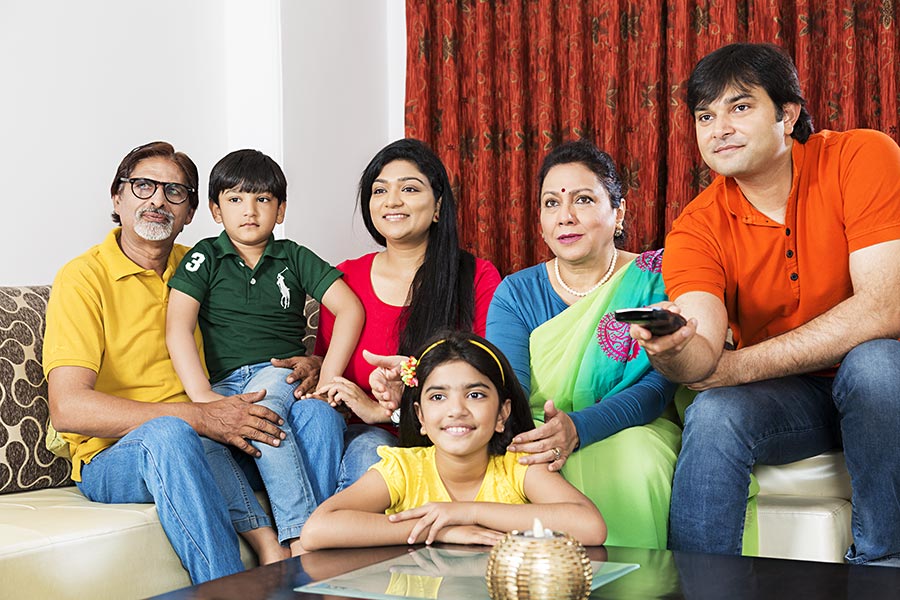 Indian Joint family sitting on sofa Watching tv At Home