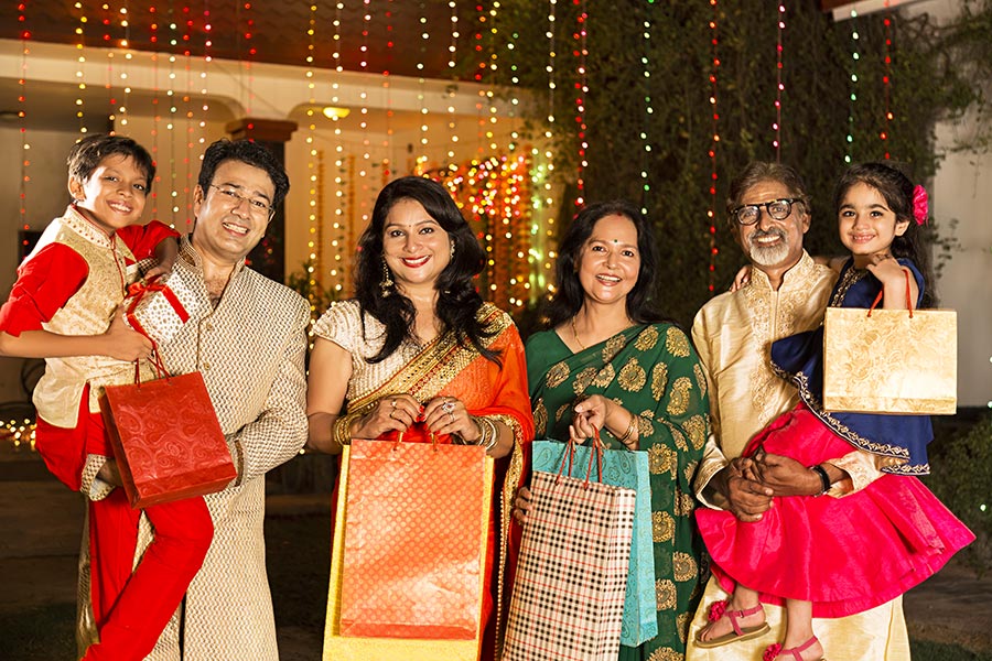 Indian Three-generation Family Holding Shopping-Bags Standing Outside ...