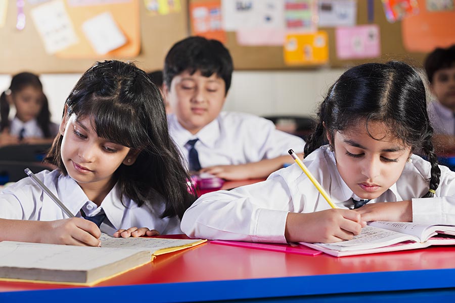 Indian Primary School Kids Students Studying Writing Notebook In-Class