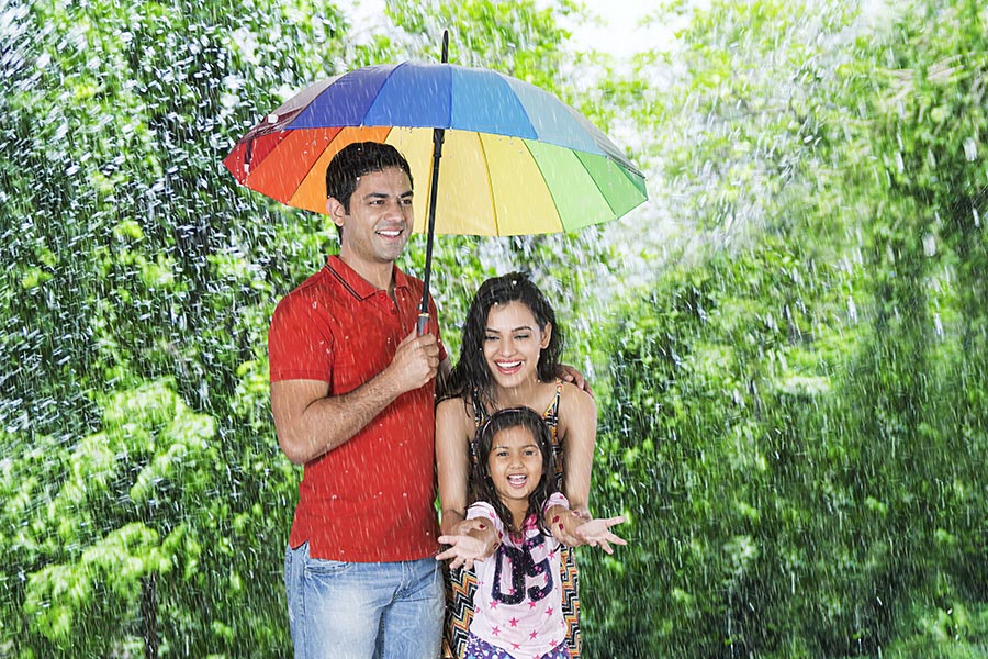 Happy Family under the rain holding umbrellas Having Fun Park