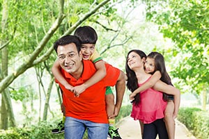 Parents Giving Children Piggyback Rides Park