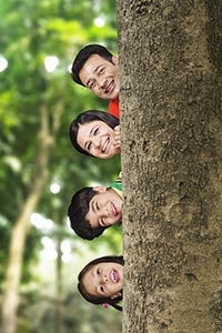 Portrait Parents Kids Peeking Behind Tree